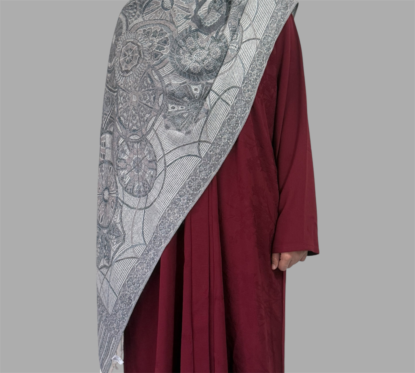 Maroon garment with a Silver patterned shawl on a gray background