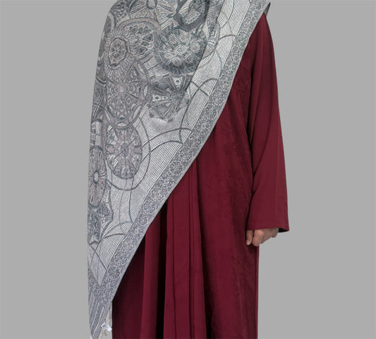 Maroon garment with a Silver patterned shawl on a gray background
